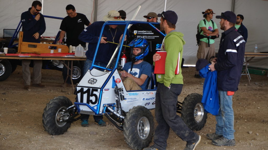 The distances from Justin's helmet to the roll cage are checked for compliance with the SAE Baja rule book.
